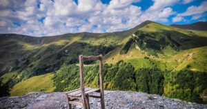 A Worn Down Wooden Chair On Top Of A Hill Surrounded By Green Mountains in Macon, Georgia.